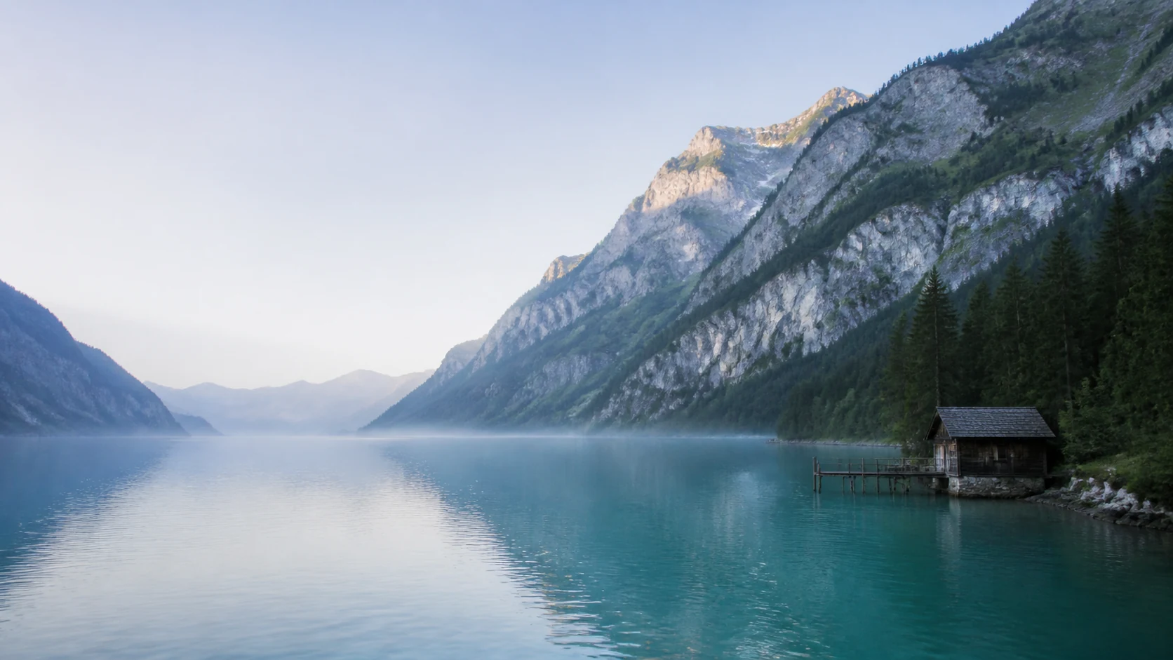 Still turquoise lake surrounded by alpine peaks in Switzerland